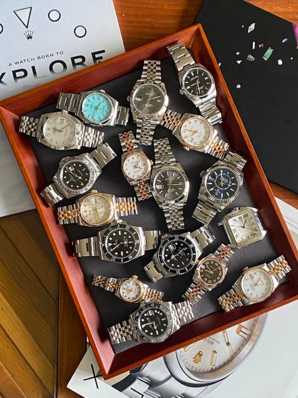 A wooden tray of vintage Rolex Datejusts, bracelets overlapping